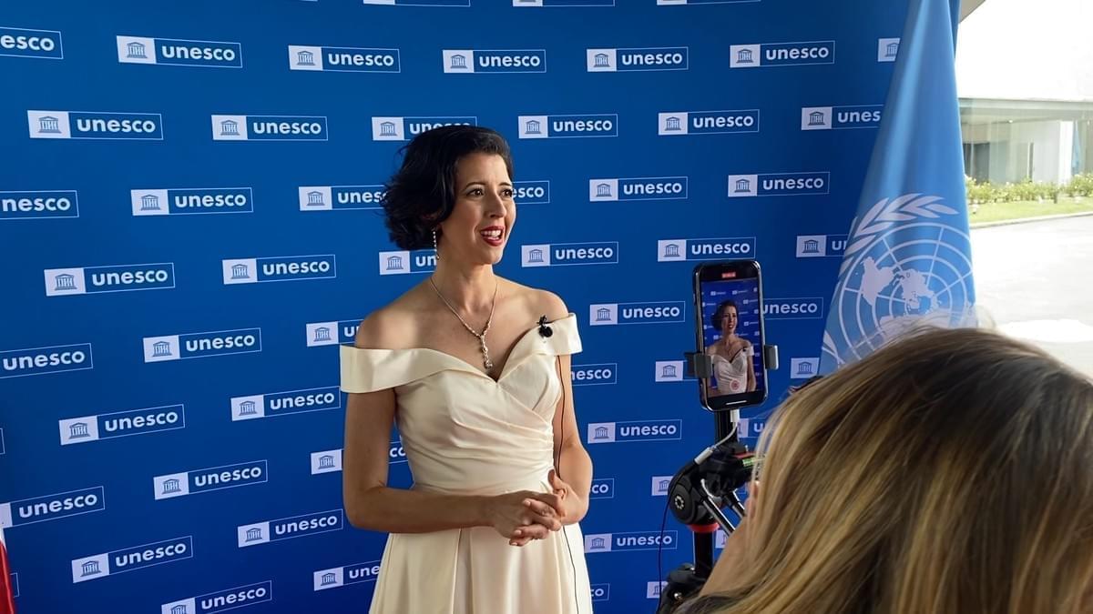 Lisette Oropesa giving an interview at the flag raising for the rejoining of the United States to UNESCO